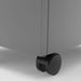 Left angled close up wheel detail of a contemporary three-drawer silver locking file cabinet with wheels on a white background