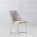 Right-angled modern glam white microfiber dining chair with a geometric base in an empty room