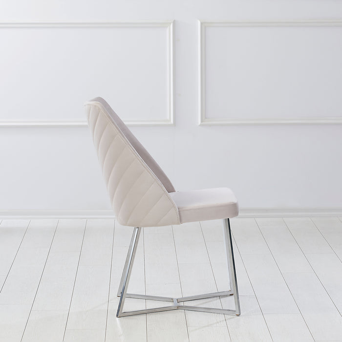 Front-facing side view of a modern glam white microfiber dining chair with a geometric base in an empty room