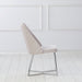 Front-facing side view of a modern glam white microfiber dining chair with a geometric base in an empty room