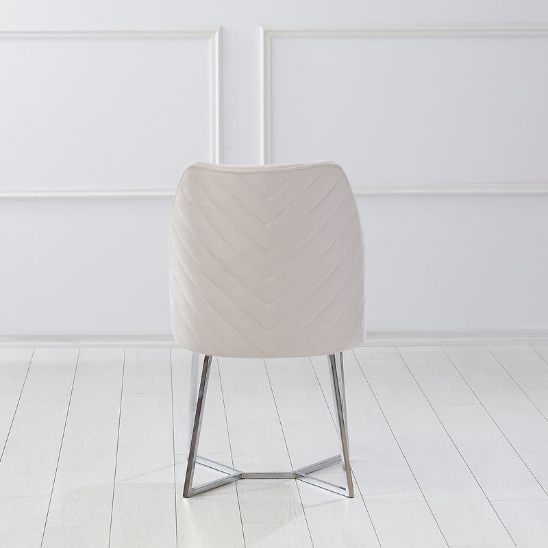 Front-facing back view of a modern glam white microfiber dining chair with a geometric base in an empty room