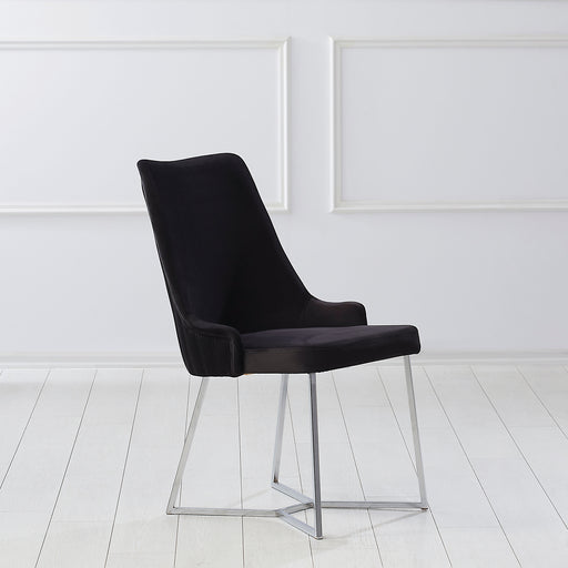 Right-angled modern glam black microfiber dining chair with a geometric base in an empty room