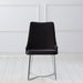 Front-facing modern glam black microfiber dining chair with a geometric base in an empty room