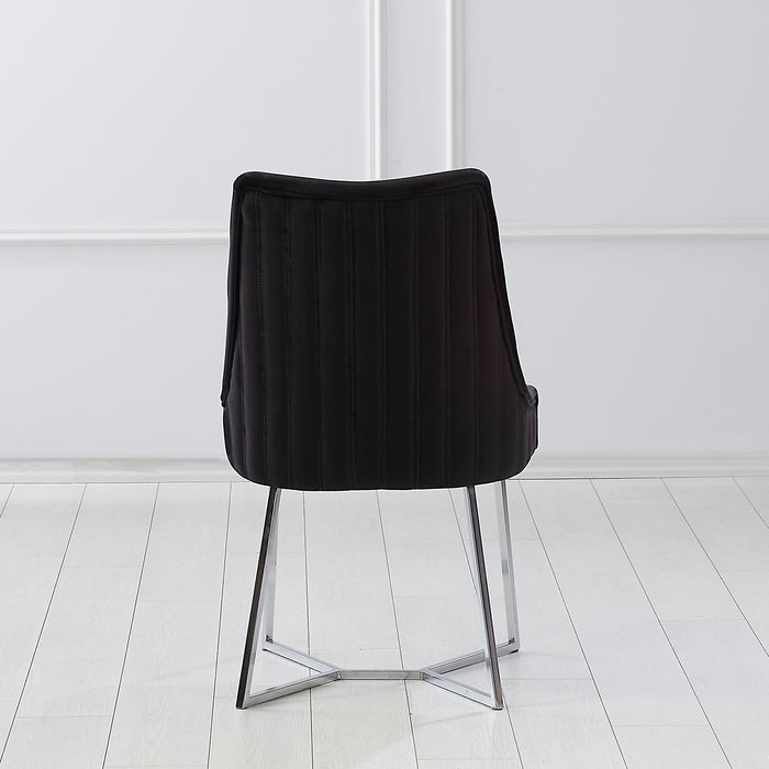 Front-facing back view of a modern glam black microfiber dining chair with a geometric base in an empty room