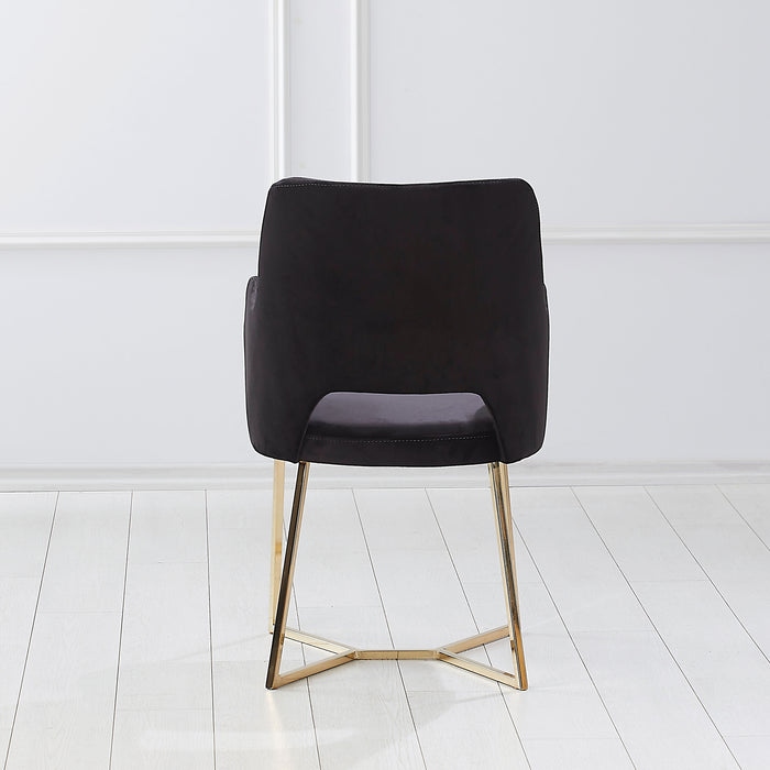 Front-facing back view of a modern glam black microfiber dining armchair with a geometric base in an empty room