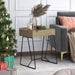 Modern champagne end table next to a Christmas tree with gold ornaments.