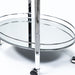 Left angled close up contemporary chrome and tempered glass serving cart with two shelves shelf and wheel detail on a white background