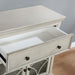 Right angled close up of a traditional antique white one-drawer hallway cabinet with drawer open in a living area