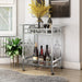 Left-angled contemporary chrome and tempered glass serving cart with quatrefoil accents in a living area with accessories