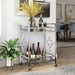 Right angled contemporary chrome and tempered glass serving cart with quatrefoil accents in a living area with accessories