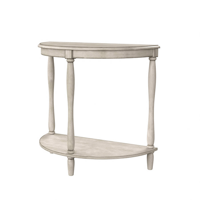 Left-angled demi-lune accent table in an antique white finish with turned legs on a white background