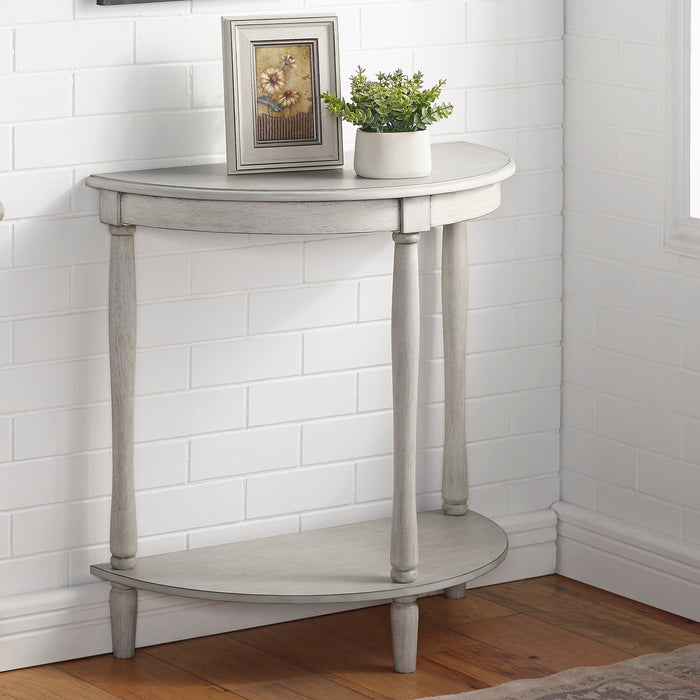 Right-angled demi-lune accent table in an antique white finish with turned legs in a casual living space with accessories