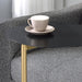 Right angled close up contemporary black and gold C-shaped side table tabletop detail in a living room with accessories