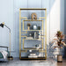 Front-facing modern glam geometric etagere bookcase in gold upper right shelf and geometric detail on a light gray wall with accessories