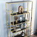 Right-angled close up modern glam geometric etagere bookcase in gold upper right shelf and geometric detail on a light gray wall with accessories