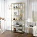 Left-angled modern glam staggered shelf etagere bookcase in gold with six shelves in a contemporary living space with accessories