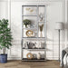 Front-facing modern glam staggered shelf etagere bookcase in chrome with six shelves in a contemporary living space with accessories