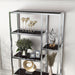 Front-facing close up modern glam staggered shelf etagere bookcase in chrome with six shelves in a contemporary living space with accessories