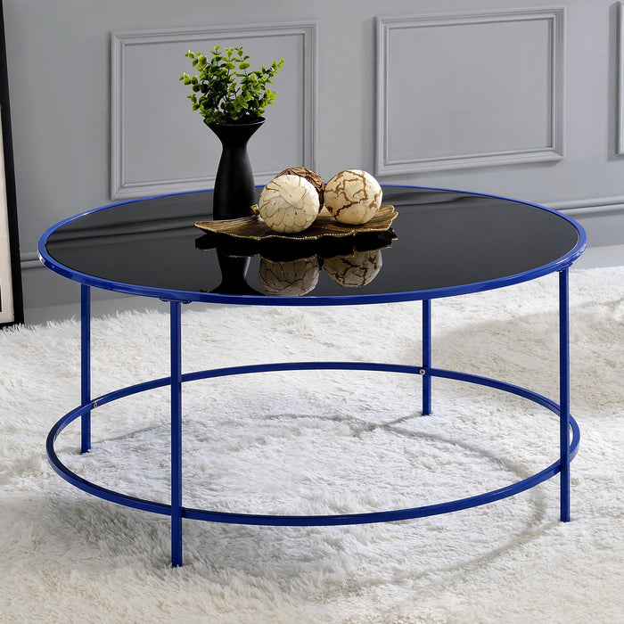 Front-facing contemporary blue and black glass round coffee table in a living room with accessories