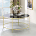 Front-facing contemporary champagne and black glass round coffee table in a living room with accessories