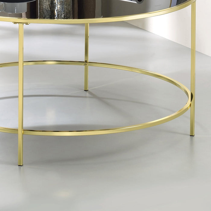 Front-facing close up base detail of a contemporary champagne and black glass round coffee table in a living room