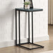 Left angled urban black and antique blue C-shaped rectangular side table in a living area with accessories