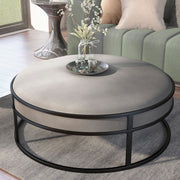 Left angled contemporary gray and black round ottoman in a living room with accessories