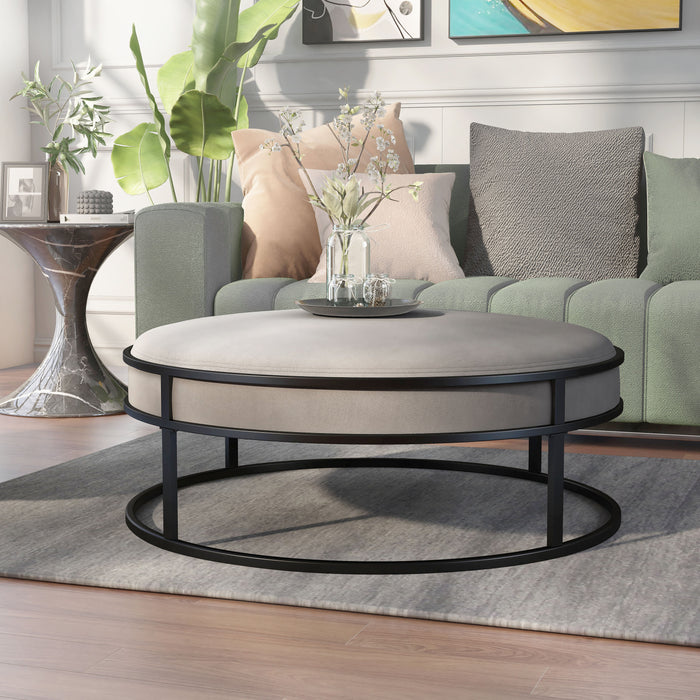 Left angled contemporary gray and black round ottoman in a living room with accessories