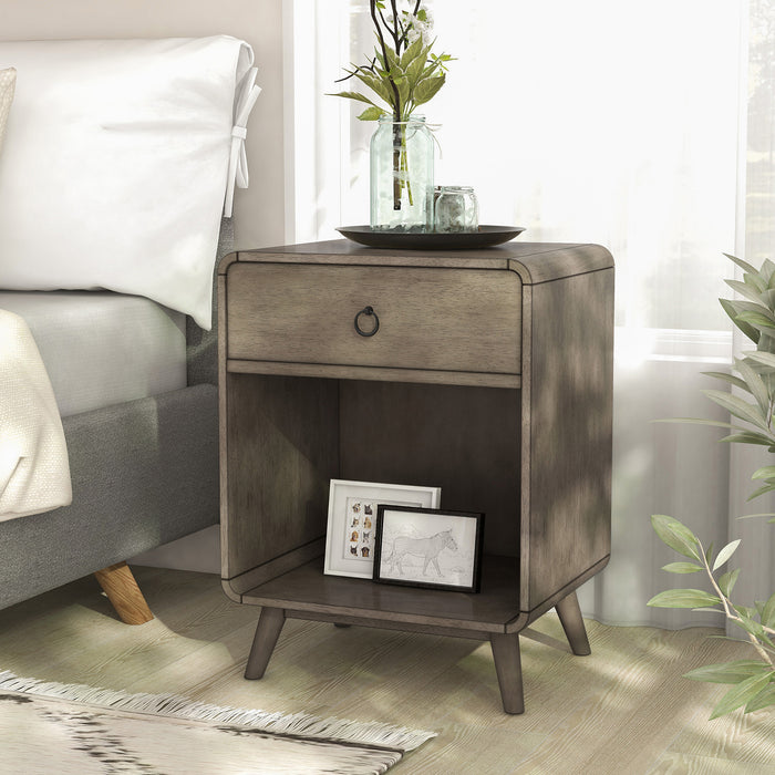 Left angled mid-century modern one-drawer gray wood side table in a bedroom with accessories.