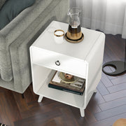 Top-view of a mid-century modern antique white side table with single drawer and open bottom cabinet space decorated next to a sofa in a living room.