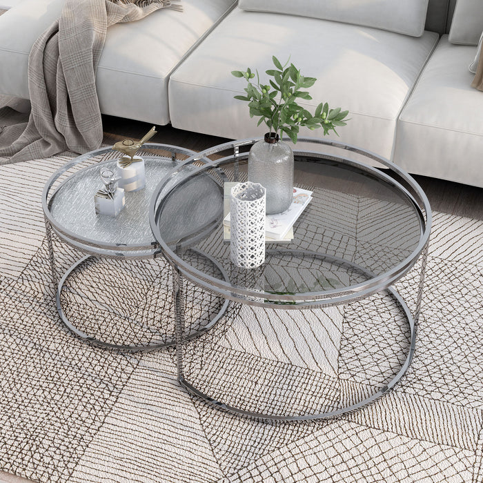 Right angled top view of glam chrome and gray glass two-piece nesting tables in a living room with accessories