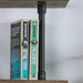 Front-facing close up industrial natural and sand black wall shelf support detail on a wall with accessories