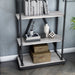 Left-angled close up industrial antique white and black five-shelf bookcase in a sitting area with accessories