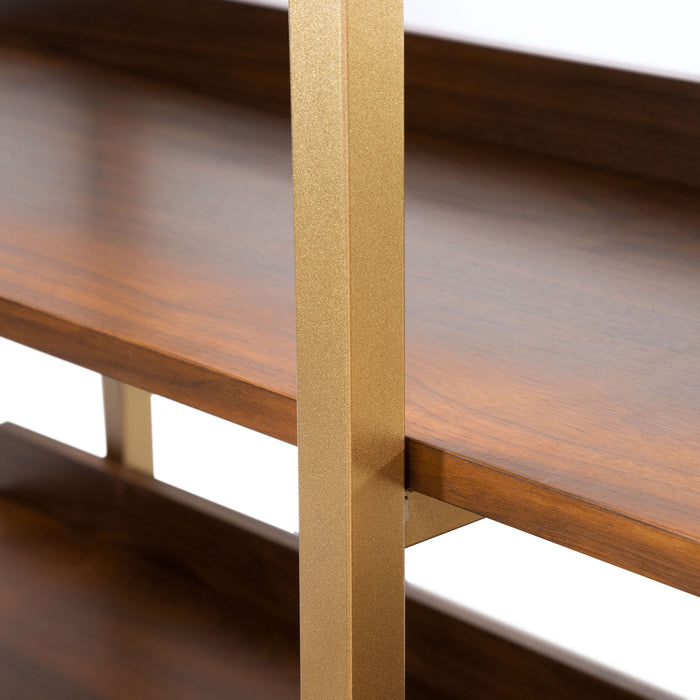 Left angled close up middle shelf and leg detail of a contemporary three-shelf light walnut and gold bookcase on a white background