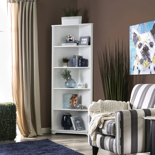 Left angled contemporary white solid wood five-shelf corner bookcase in a living area with accessories