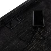 Angled incomplete top-down view of desktop section of black metal and MDF urban desk with charging outlets on white background