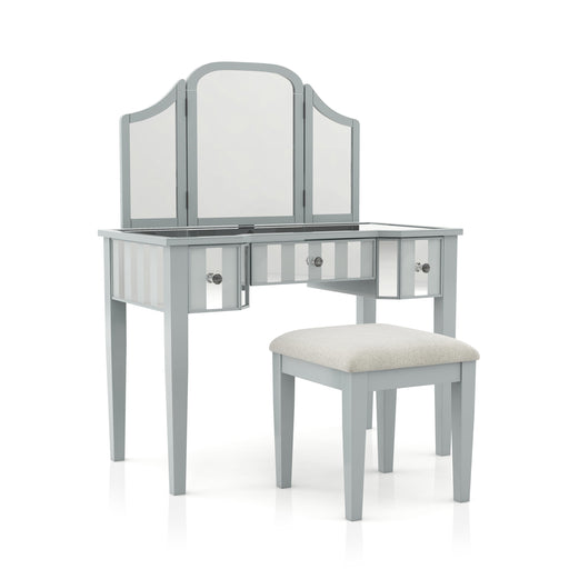 Right-angled silver vanity set against a white background. This vanity table features a trifold mirror, mirrored tabletop, and stripe frosted mirrored drawers with acrylic knobs. It stands on long tapered legs to match the fabric-top stool.