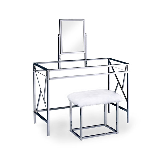 Right angled chrome vanity set against a white background. The table comes with an attached rotating rectangular mirror. A glass top is paralleled with a shelf to maintain an open and airy design. Continuing the chic look are two legs on each side joined by a geometric bar design. A chrome stool is upholstered in white faux fur.
