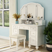 Left-angled white vanity set in a contemporary sky blue bedroom. Creams, incense, and a marble clock sit on the vanity table. To the left is a window with off-white curtains to match the natural tone colors of the striped rug under the stool seat.