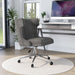 Right angled gray and chrome wingback office chair at a desk with accessories