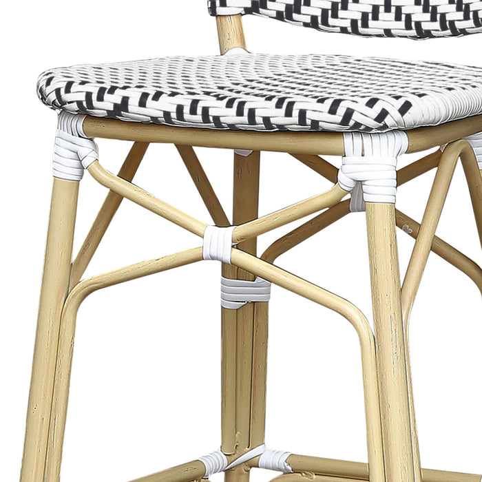 Detail shot of a black and white chevron patterned wicker patio bar chair with a natural tone frame.