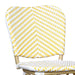 Detail shot of a yellow and white chevron patterned wicker curved backrest.