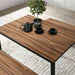 Left angled close up walnut and black three piece dining table set with benches in a dining room with accessories