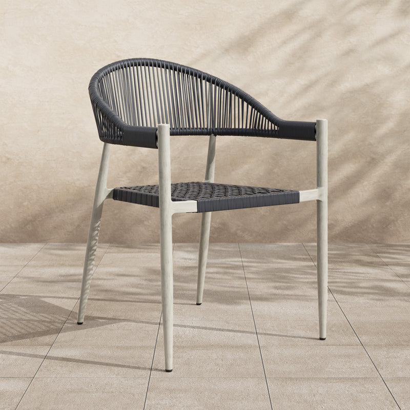 Right-angled bohemian faux wicker patio dining chair in light gray in an outdoor space