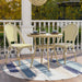 Natural tone and yellow wicker bistro set on a porch. The table sits on a round rug, offering two cups of tea. A chevron pattern wicker adds style to the set.