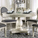 Front-facing traditional round antique white dining table in a stylish dining room with accessories