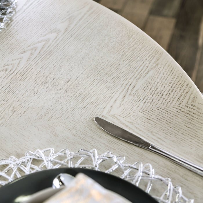 Top-down close-up view of the tabletop on a traditional round antique white dining table in a stylish dining room with accessories