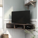 Left angled modern walnut oak floating corner TV stand in a living area with accessories