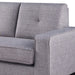 Left-angled close up contemporary gray upholstered loveseat tufted back and smooth seat cushion and track arm detail on a white background