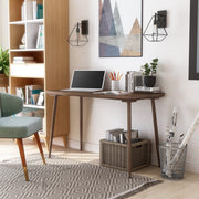 Angled right-facing view of contemporary walnut oak finish desk in living space with accessories